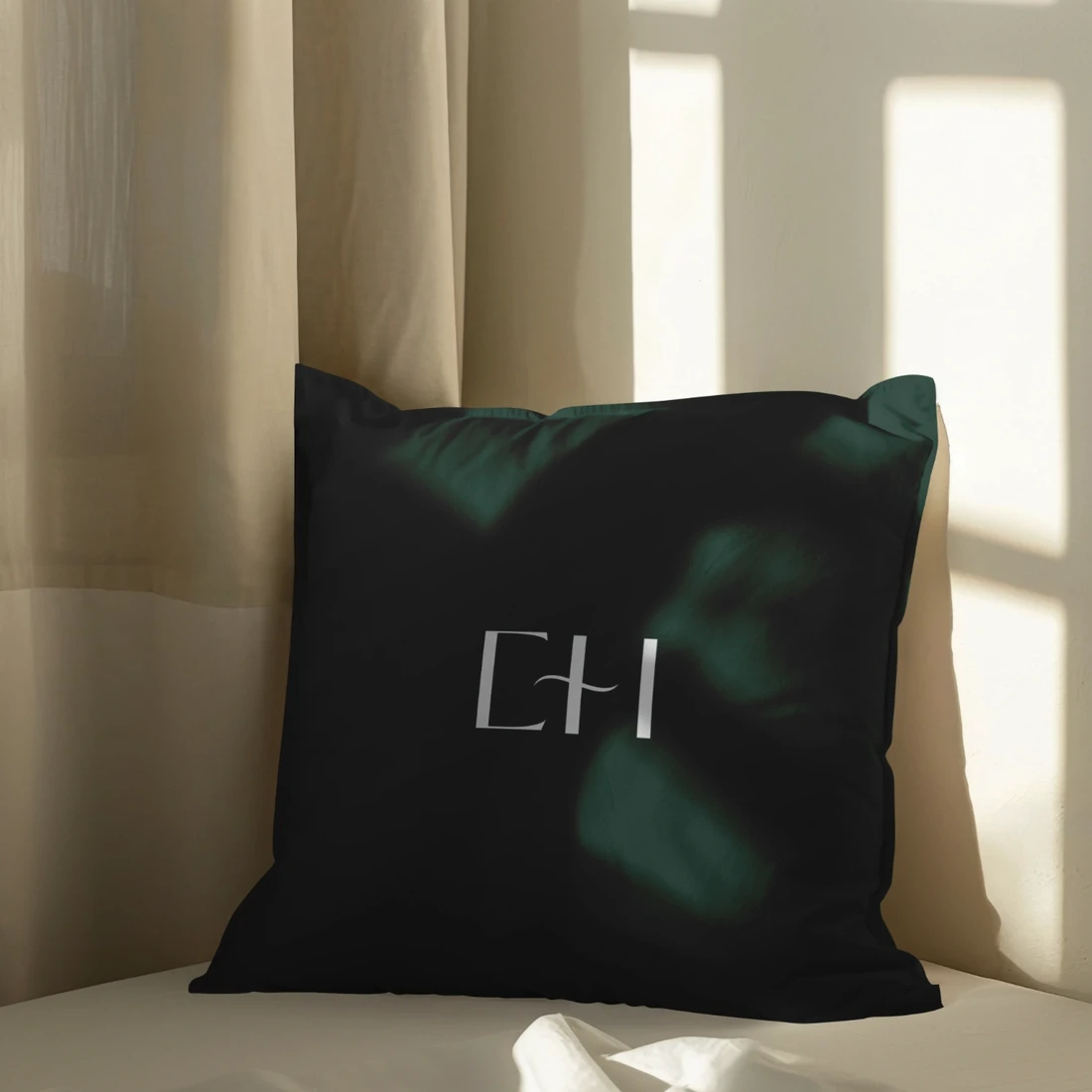 Branded cushion on a bed in natural sunlight